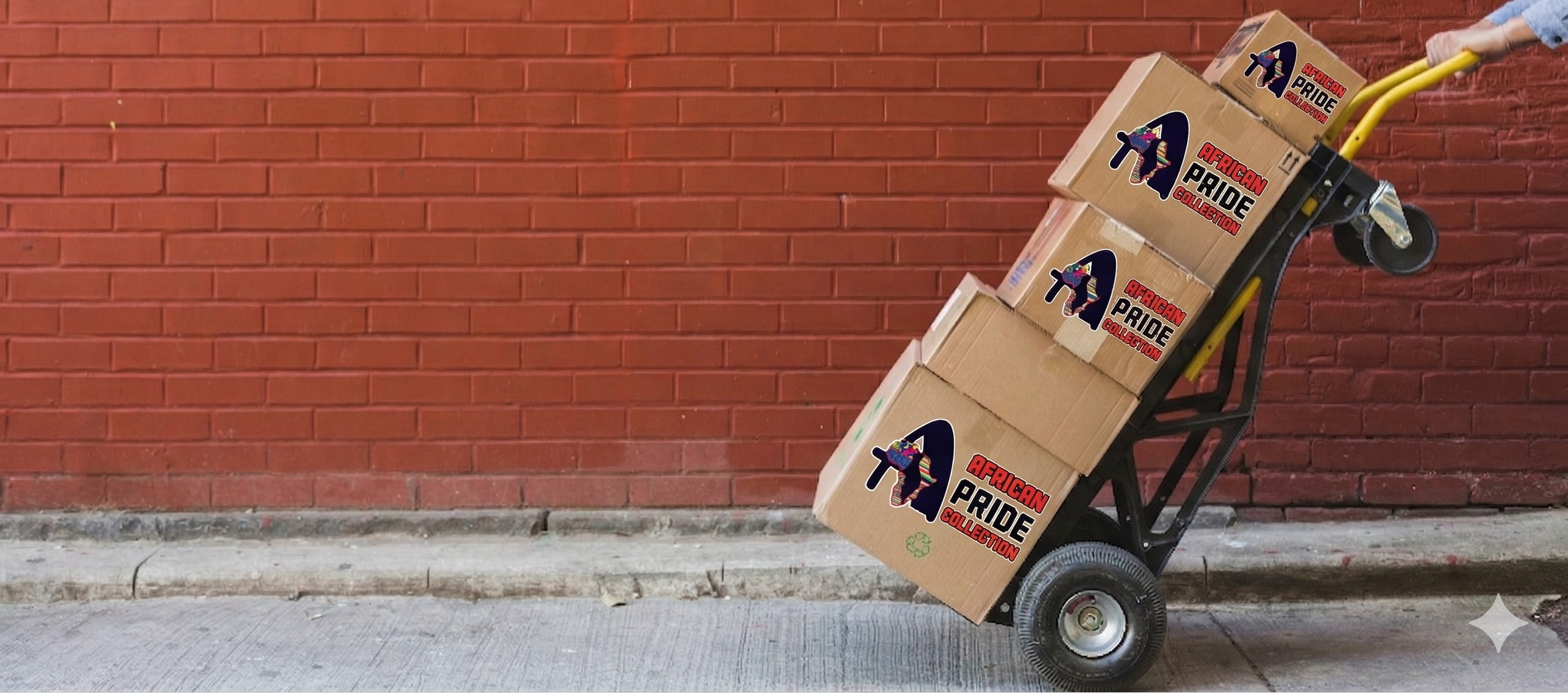 Hand truck with boxes labeled 'Pride' against a red brick wall.