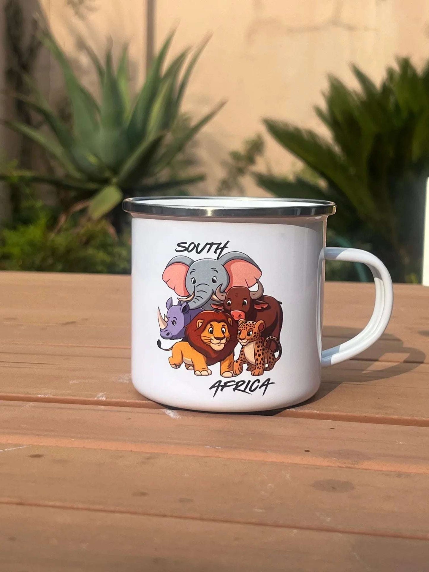 Custom enamel mug showcasing African wildlife characters and 'South Africa' text, perfect for outdoor adventures.