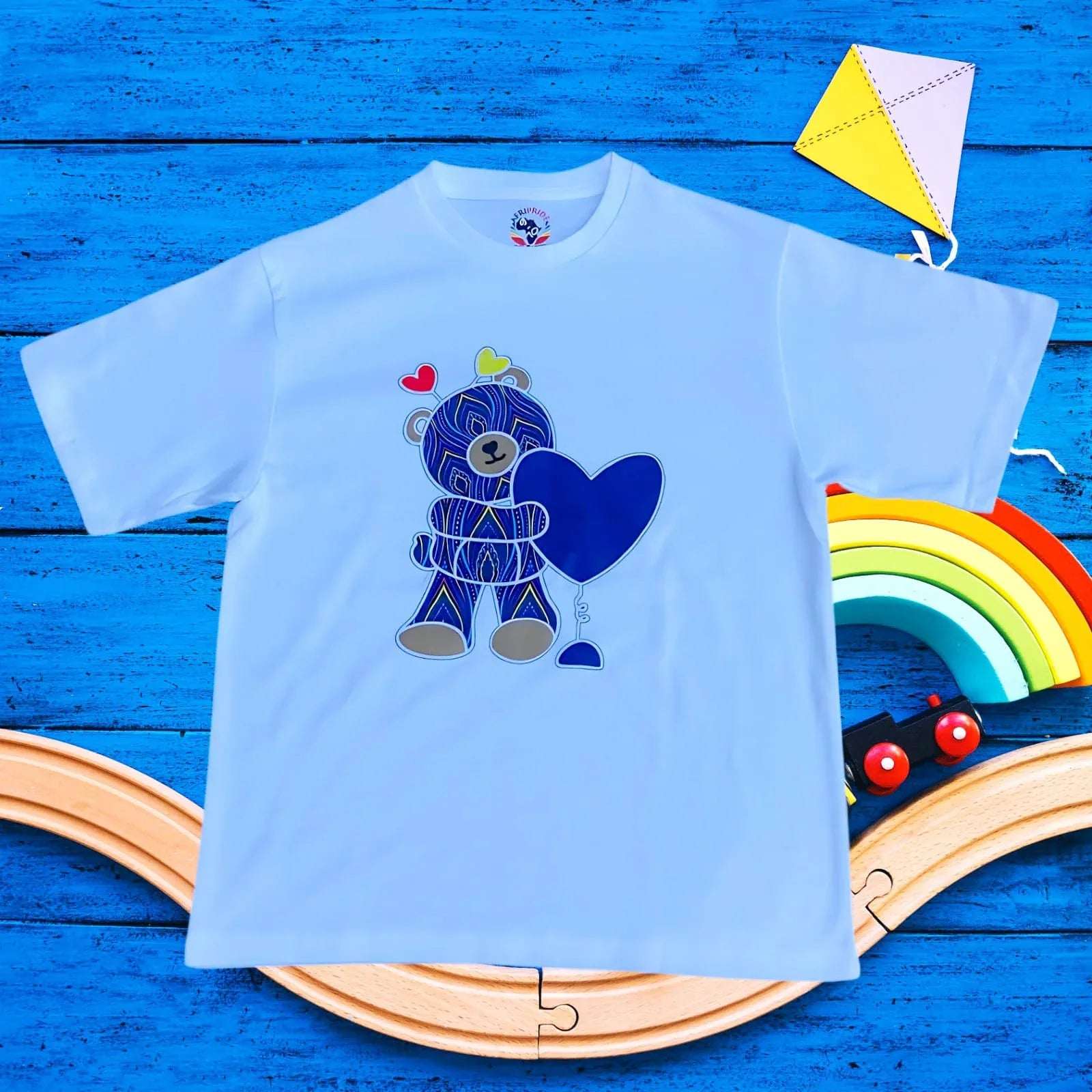 Blue kids T-shirt with African fabric-style TeddyBear holding a blue heart. Made from 100% cotton, ideal for playful comfort.