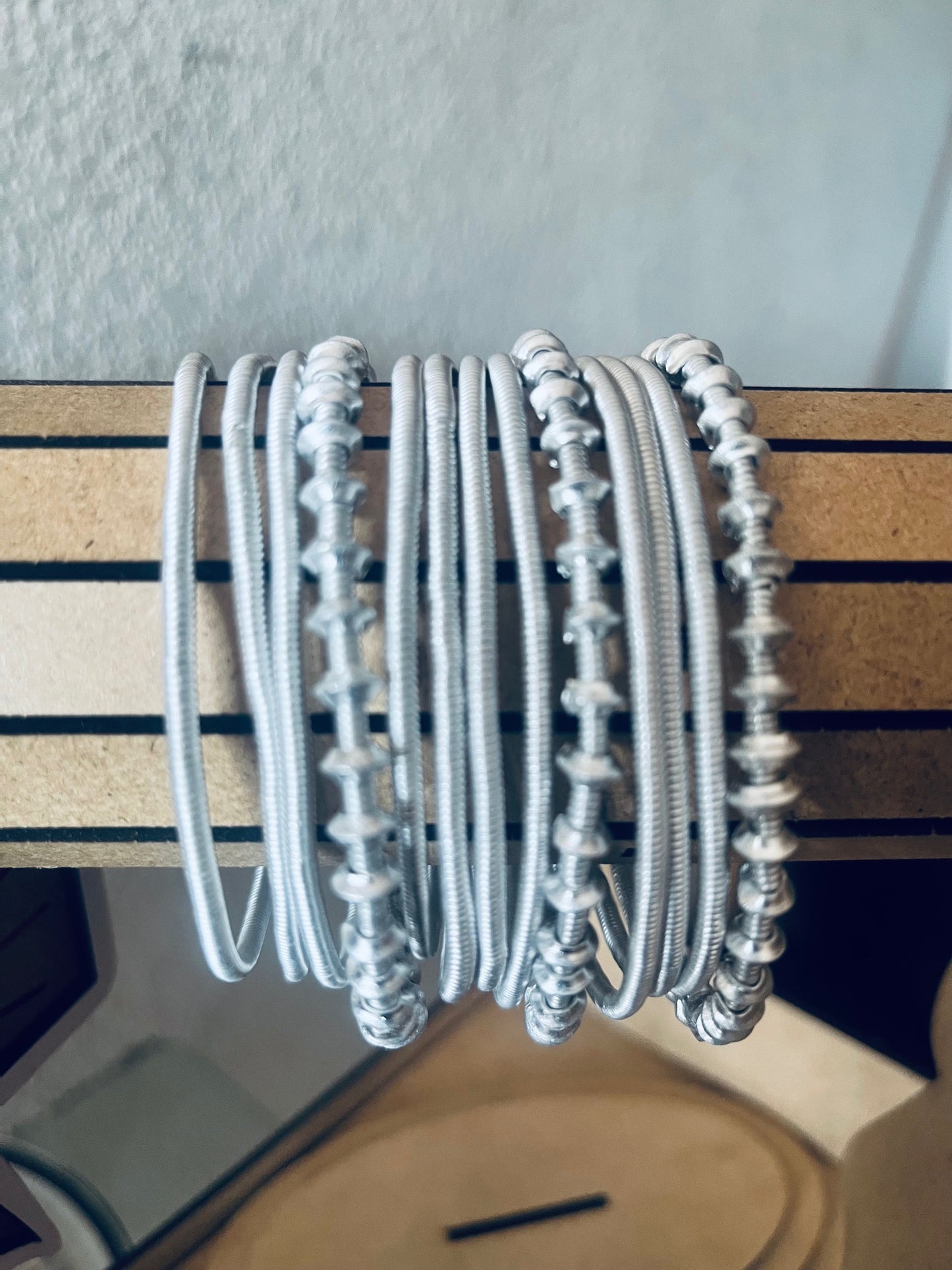 Multiple Venda Bangles/bracelets stacked on a wooden surface with a neutral background